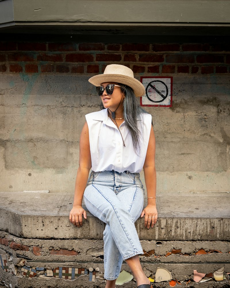 Mulher com camisa branca sem manga e calça jeans