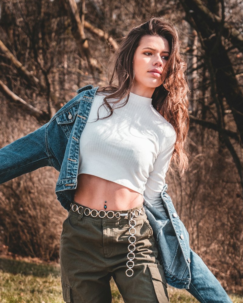 Mulher com cropped canelado, jaqueta jeans e calça cargo